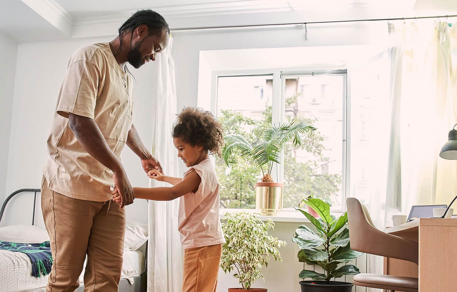 Parent and child holding hands in room